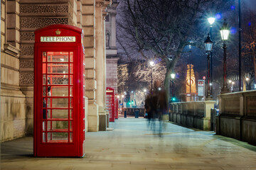 Red vintage London phone booth long exposure. Photo taken along the sidewalk of Parliament Square. Photo taken in the evening in London United Kingdom