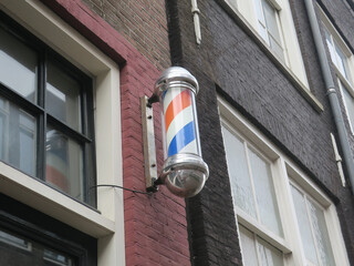 sign of a hairdreser with whirling  red, white and blue stripes
