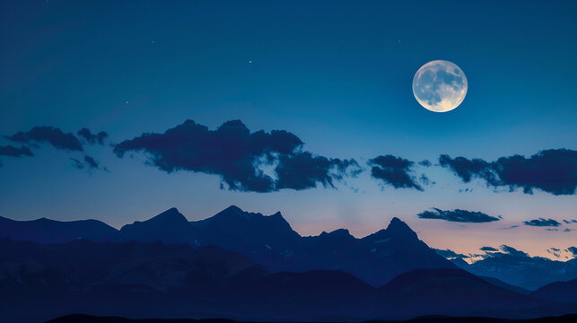 A bright full moon lights up soft clouds floating above towering mountains under a calm night sky. - Powered by Adobe