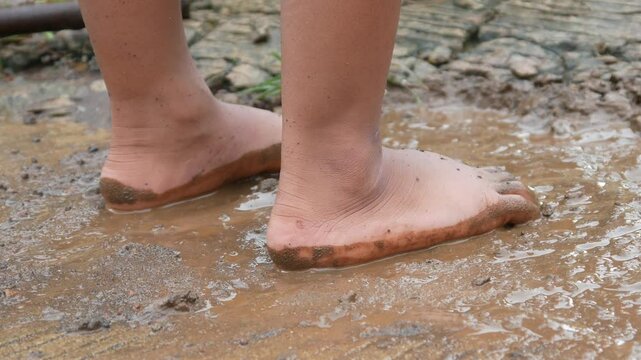 small child's feet on wet ground or mud