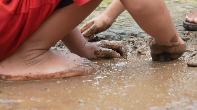 Mud covered hands of a child.  Children playing in mud