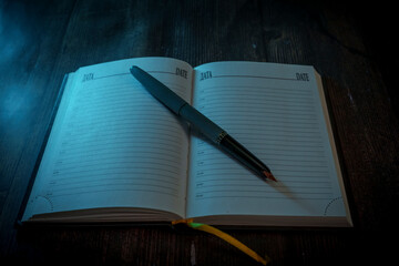 Open planner with fountain pen in moody lighting