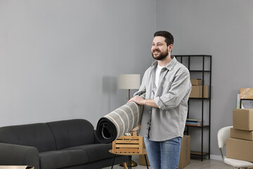 Moving day. Man with rug in his new home