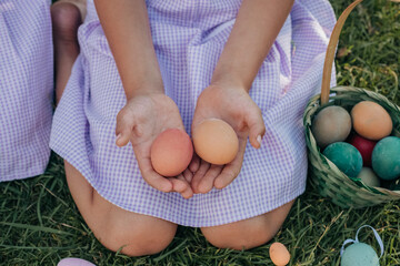 Child holding colorful Easter eggs in a grassy field