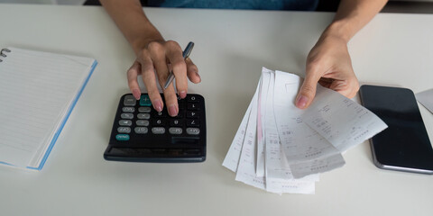 Budgeting and Expense Tracking. A person calculating expenses with receipts and a calculator,...