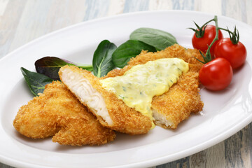 fried basa fish fillet with tartar sauce.