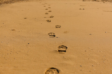 Close-up of a Shoe Print on the Sand at the Beach, leaving a mark on the surface of the sand