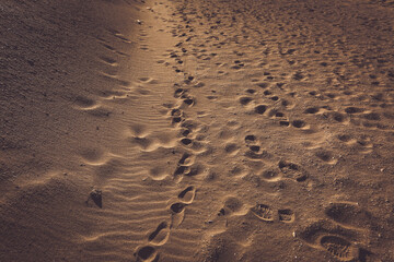 Close-up of a Shoe Print on the Sand at the Beach, leaving a mark on the surface of the sand