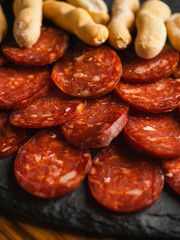 Chorizo cortado en rodajas junto a picos de pan.