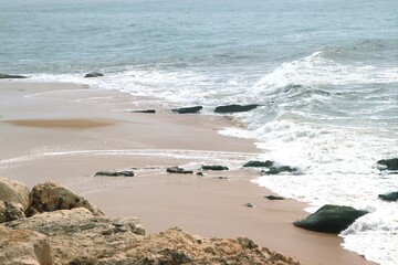 Ocean shore close-up. Wet sand. Sea foam. Waves. Color image. Poster. Wallpaper. Background. Postcard.