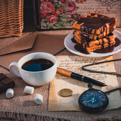Vintage still life with coffee, chocolate waffles, letters, and pocket watch