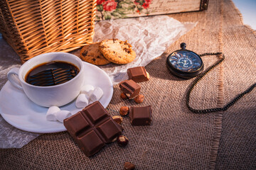 Vintage still life with coffee, chocolate, cookies, and pocket watch