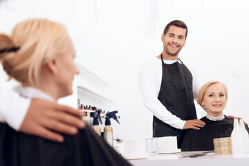 Obraz premium Hairdresser chooses haircut for mature attractive woman in beauty salon.