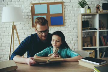 Red haired father in glasses reads fairy tale