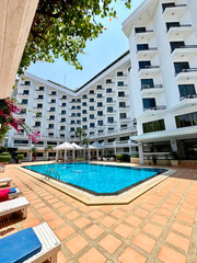 Thailand. Relaxing courtyard features a bright pool surrounded by blooming plants and a stylish hotel in Pattaya.