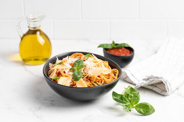 pasta with tomato sauce, parmesan and basil, light background