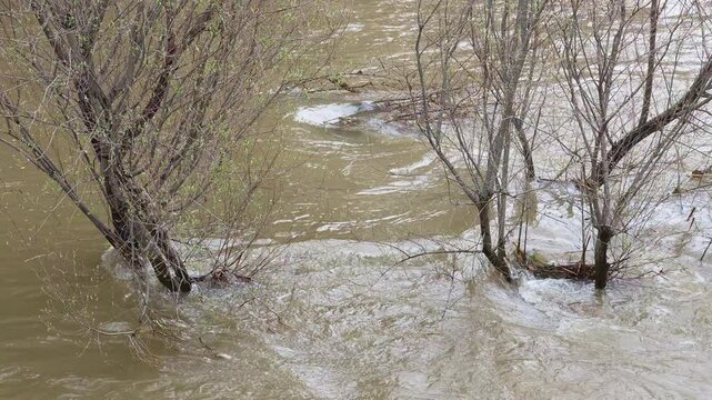 Madrid, Spain; March, 21, 2025: The Manzanares River overflowing. Slow motion footage of strong river currents. Powerful water in movement. Mother Nature in motion. 