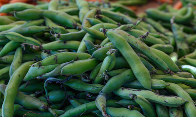 Freshly harvested green beans on display at a vibrant local farmers market in summer sunlight