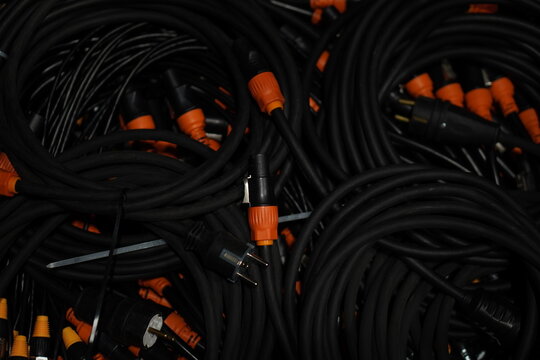 Black thick cables wires with orange tips close-up