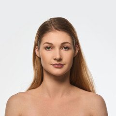 Fototapeta premium Portrait of young beautiful woman with flawless skin, straight posture, calm expression isolated on white background. Concept of female beauty, skin care, cosmetics, cosmetology, wellness.