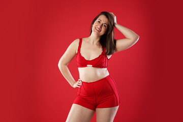 Obraz premium Woman in underwear on red background. Cellulite problem