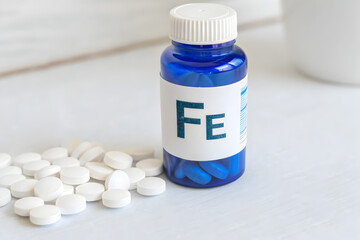 Blue Pharmaceutical Bottle with Iron Supplement, Enzymatic Function Support on Light Surface