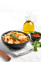 pasta with tomato sauce, parmesan and basil, light background