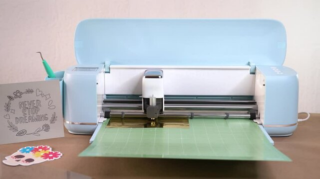 Making vinyl decorations using cutting machine in design studio workspace