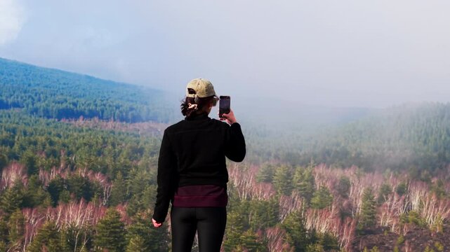 Aerial shot of a woman filming mount Etna, Sicily with her phone