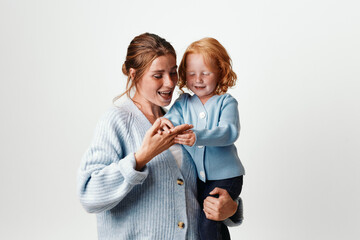 Mother and daughter embracing in joyful moment on white background, family love and happiness concept