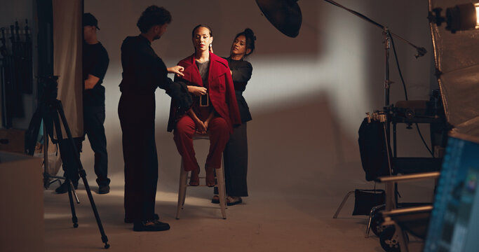 People, crew and model for photoshoot in studio of media photography, getting ready and behind the scenes. Stylist, team and prepare for film production, clothes setup and catalog of fashion industry