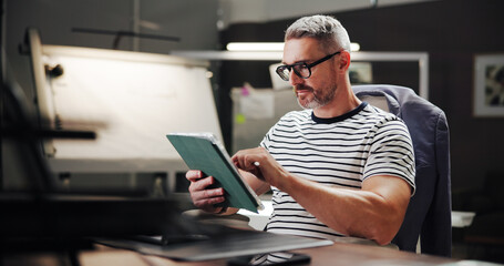 Online, night and mature man with tablet, office and creative for web design with software or...
