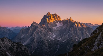 The mountain range is covered in snow and the sun is setting