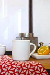 White mug with tea and lemon on a wooden table