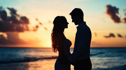 Fototapeta premium Couple silhouetted at sunset beach romance