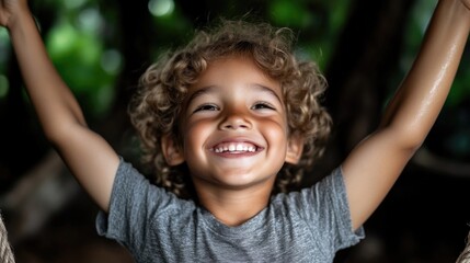 Joyful child, arms outstretched, smiling broadly.  A happy, healthy young boy, seemingly enjoying outdoor play.  Close-up, natural light