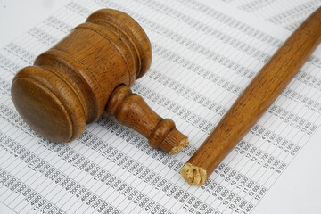 Broken wooden gavel on financial document. Wrong audition and injustice concept.	