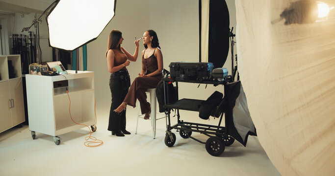 Photography, backstage and model with makeup artist in studio for production, preparing or photoshoot. Creative, media and female person with beautician for magazine editorial with behind the scenes.