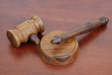 Broken wooden judge gavel on table. Concept of iniquity, injustice and not working laws.