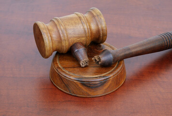 Broken judge gavel on wooden table. Concept of iniquity, injustice and lawlessness.	