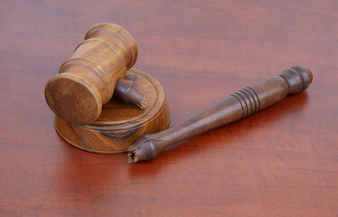 Broken judge gavel on wooden table close up. 