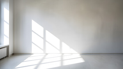 Fototapeta premium Bright and minimalistic interior room with natural light casting geometric shadows on the wall