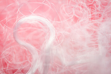 Extreme macro of polyester stable fiber on red background. Selective focus, shallow depth of field. Abstract dreamy background