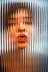 Obraz premium Face of a Woman Distorted Through Textured Glass Panel for Creative Effect
