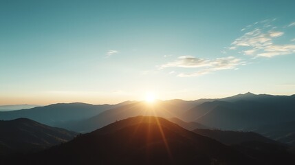 Captivating Mountain Range Sunrise with Light Rays and Clear Blue Sky