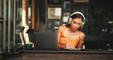 Writing, headphones and laptop with student in cafe on campus for college research, education or...