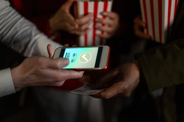 Usher scanning ticket on smartphone at movie theater