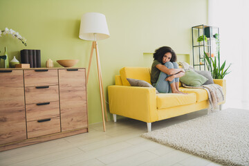 Full size photo of pretty young girl sit couch disappointed weekend pastime apartment indoors