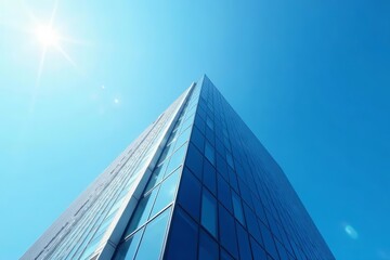 Obraz premium Looking up at modern office skyscraper against clear blue sky, glass, steel, building