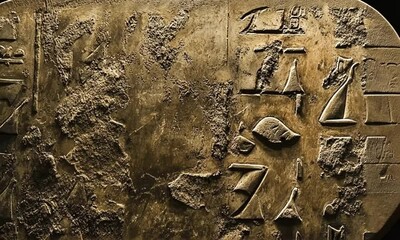 Close-up view of ancient Egyptian hieroglyphs carved into a weathered stone surface. - Powered by Adobe
